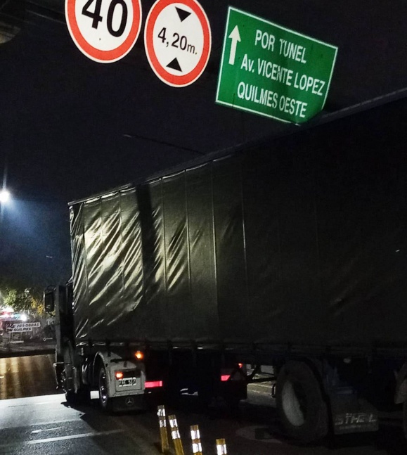 Transporte de materiales qued atorado en el cartel de ingreso al bajo vas de Guido