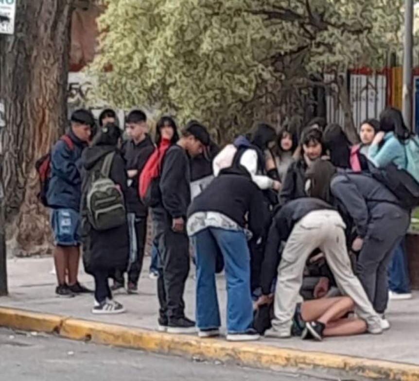 Una adolescente apual a otra en la puerta del Colegio Normal